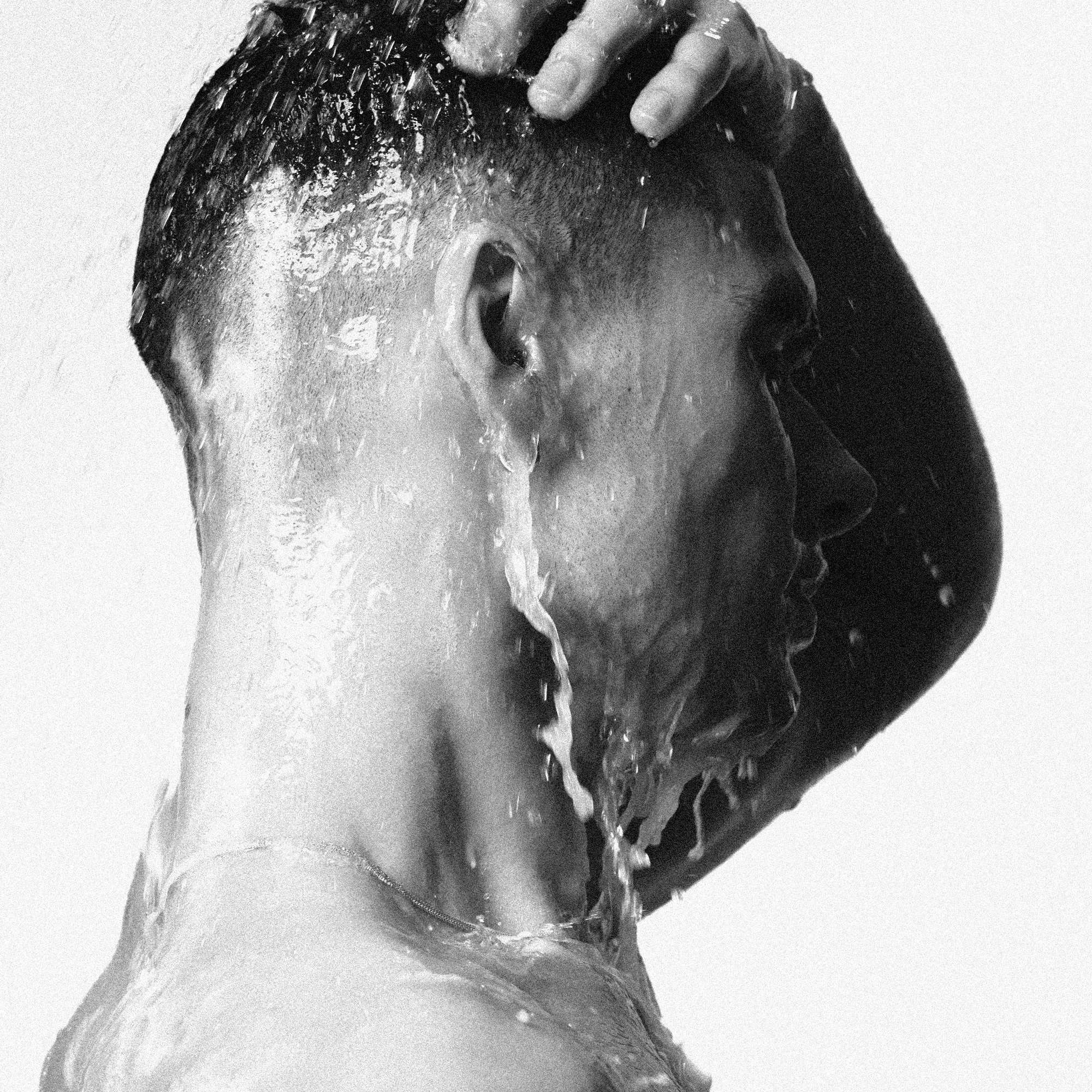 Man applying SOFTENING CONDITIONER [TRAVEL] while in the shower, showcasing moisture and softness.