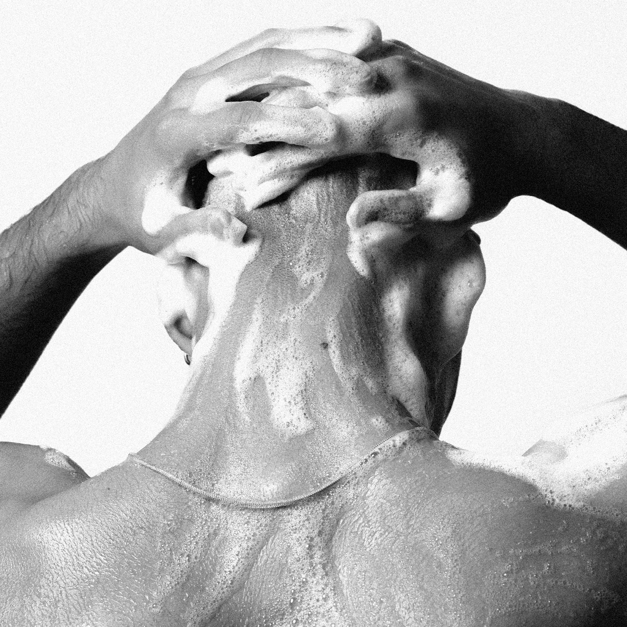 A person applying THICKENING SHAMPOO [TRAVEL] with rich lather for fuller, healthier hair.