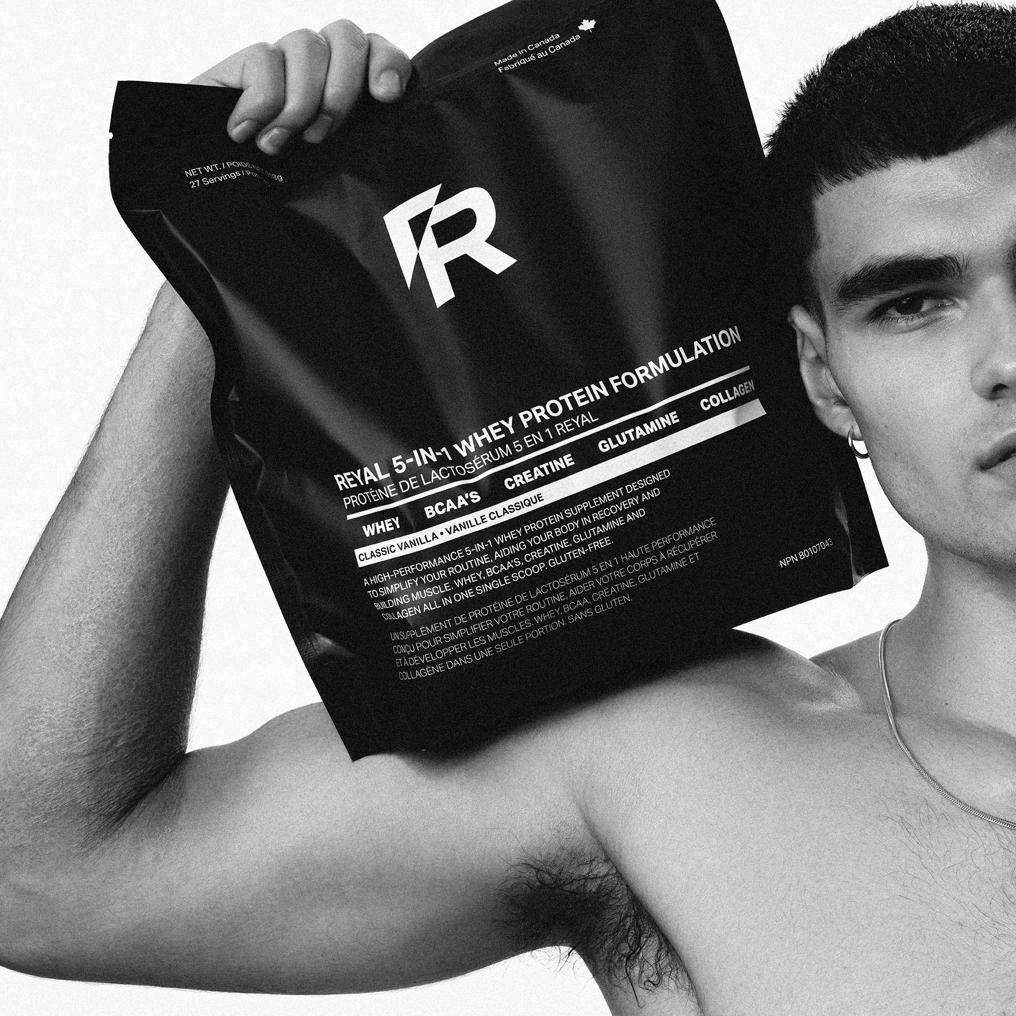 5-IN-1 REYAL WHEY PROTEIN FORMULATION [VANILLA] package held by a muscular man, showcasing high-performance supplement.